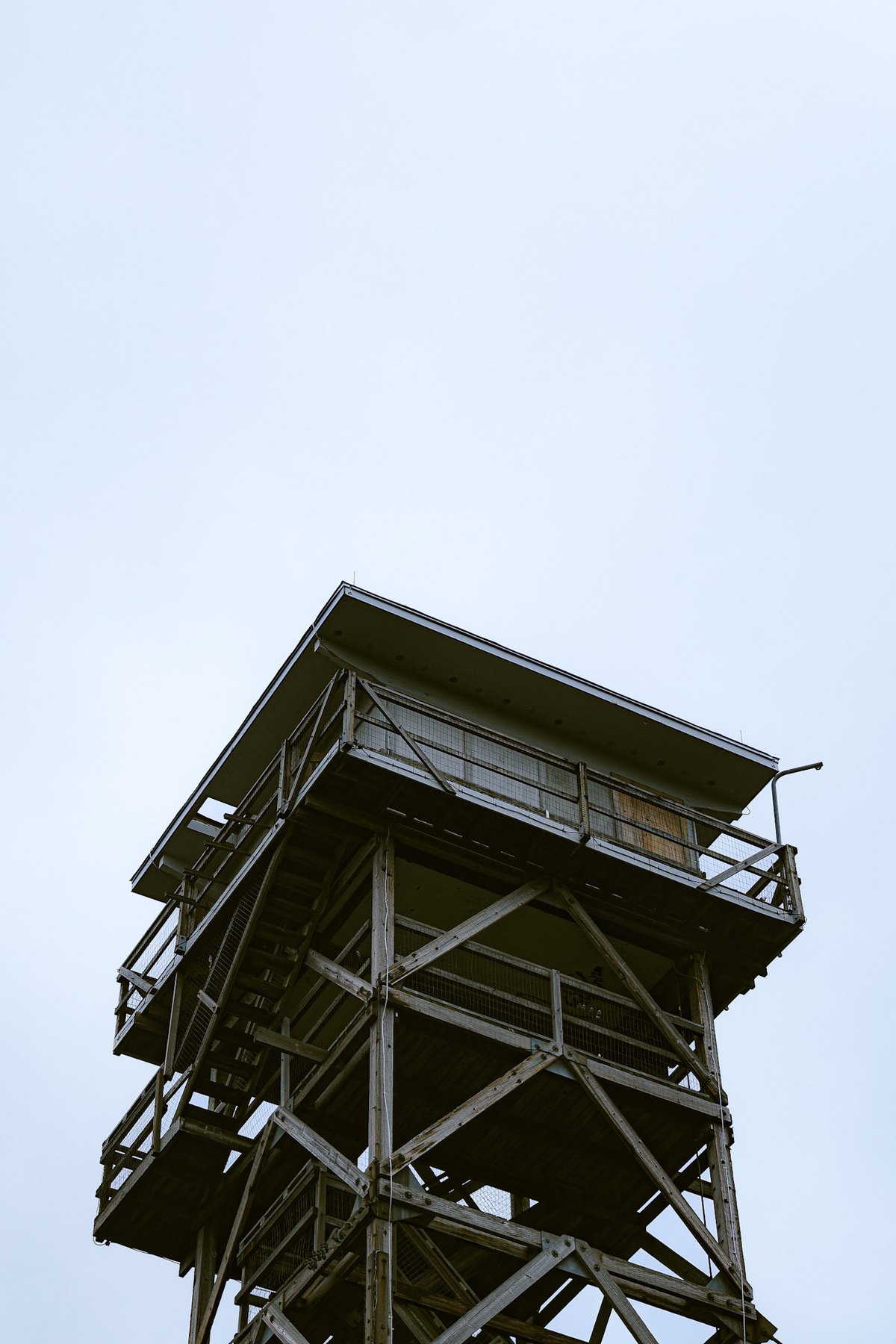 Wooden fire lookout tower silhouetted against overcast sky